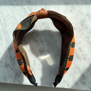 Orange and dark green head band, with faux leather bow tie decor. NWOT